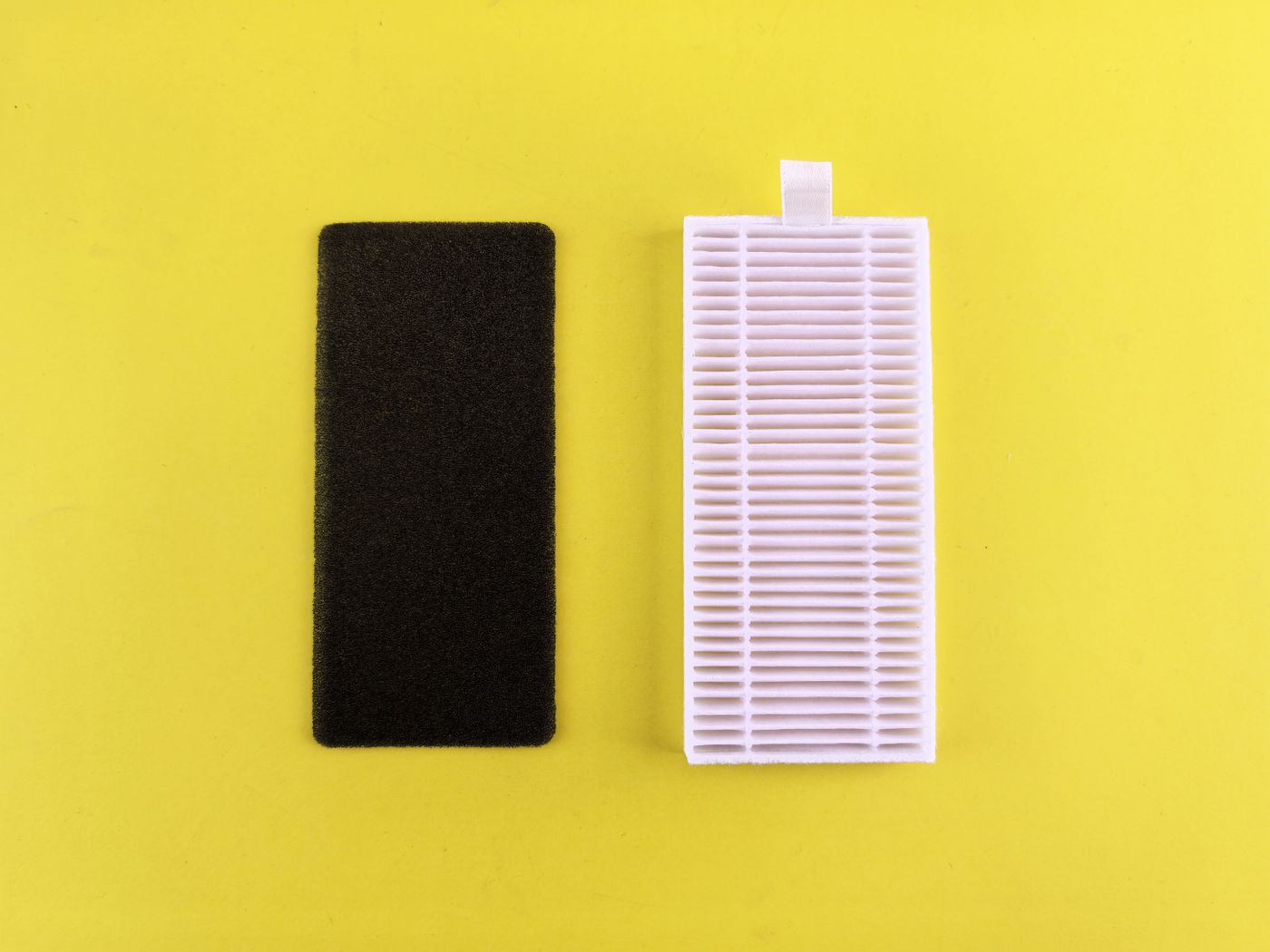 Black foam and white pleated filter elements on a yellow background.